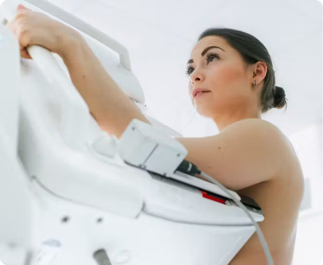 Patient positioned at a mammography unit during an exam